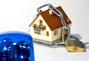 Haus mit einer Kette gesichert und einem Blaulicht im Vordergrund